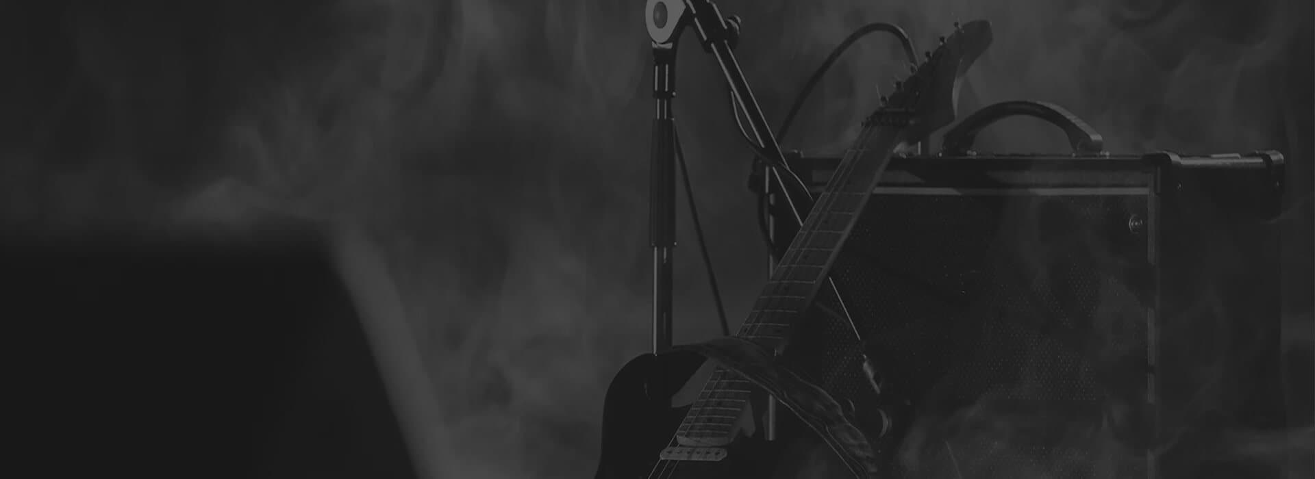 Dark stage with electric guitar and microphone stand